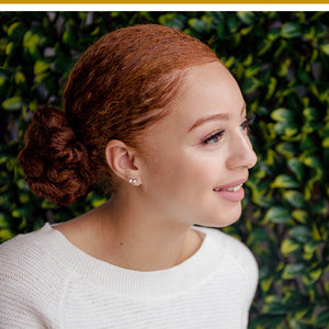 Woman with naturally curly hair styled in a low bun